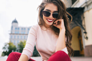 Bottom view of attractive student girl in sunglasses with snow-white smile