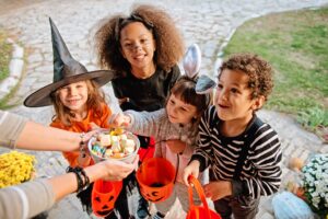 Group of kids trick or treating this Halloween, getting candy that can cause cavities