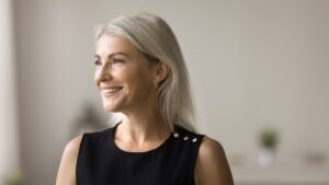 Woman with great smile after dental bridge in Mount Pleasant, Michigan