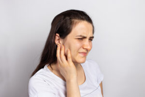 Woman with cracked tooth holding her jaw